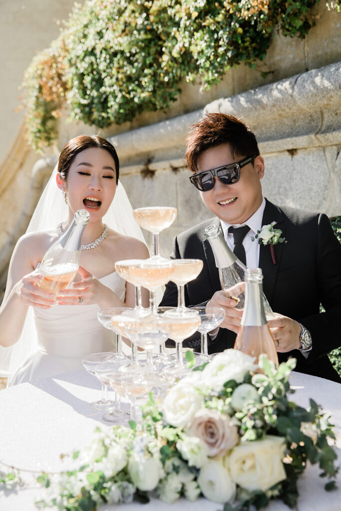 Couple celebrating an intimate French elopement with a champagne tower at a romantic château