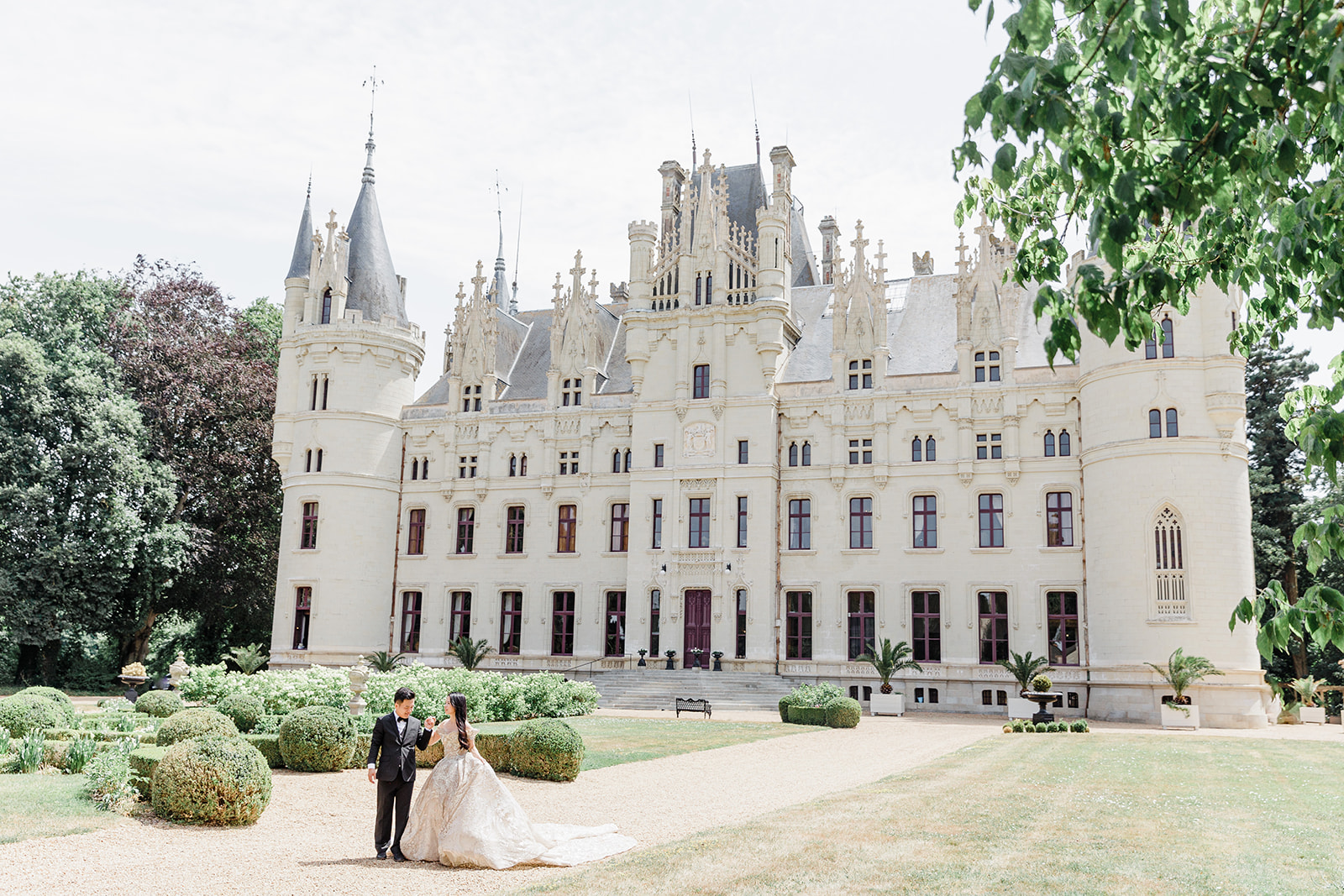 Couple for a stroll in the gardens of a fairytale chateau during their elopement in france