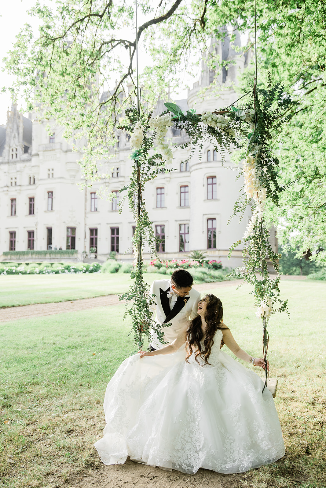Romantic photo of a couple on a swing in the gardens of a French château during an intimate elopement
