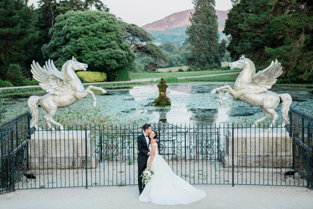 couple kissing at the gate in the gardens of Powerscourt House