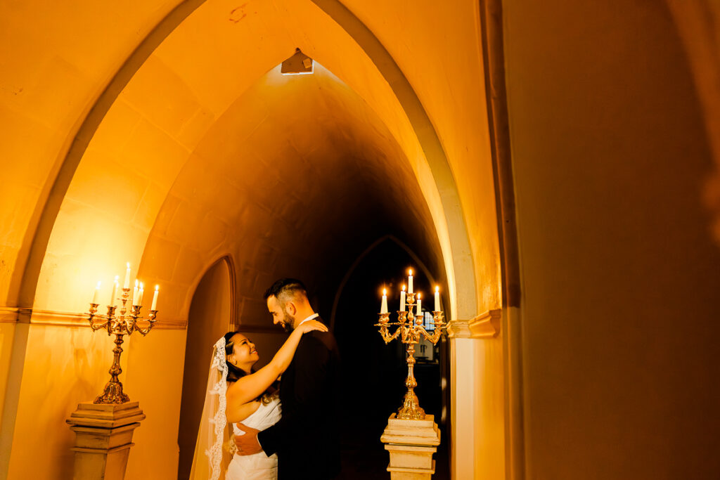 Couple embracing by candlelight inside a château in France